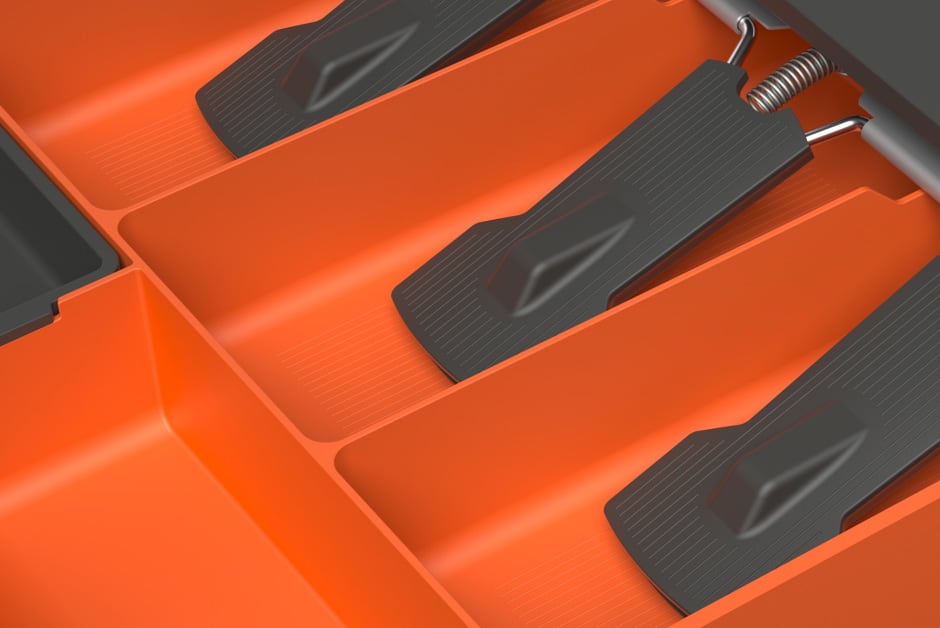 Close-up detail of the secure black bill holder components inside the orange SUUN cash drawer, ensuring notes are firmly in place.